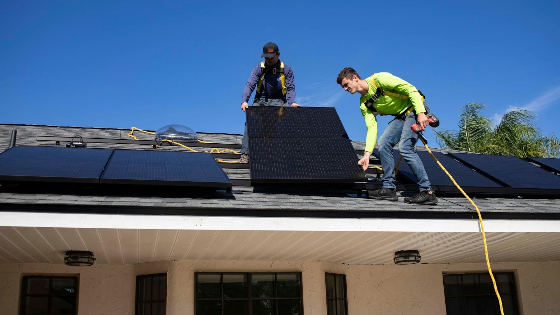 Monteure auf einem Dach bei der Montage von Solarmodulen